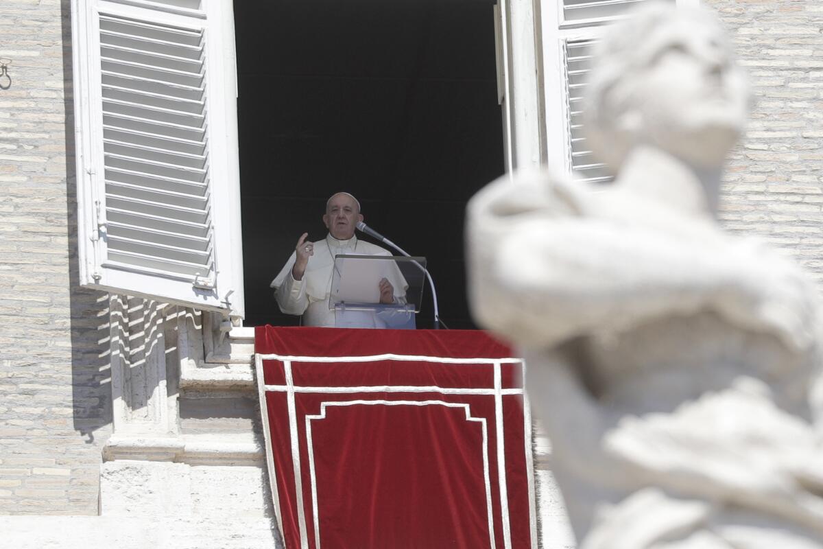 Pope Francis recites the Angelus noon prayer from his studio window overlooking St. Peter's Square.