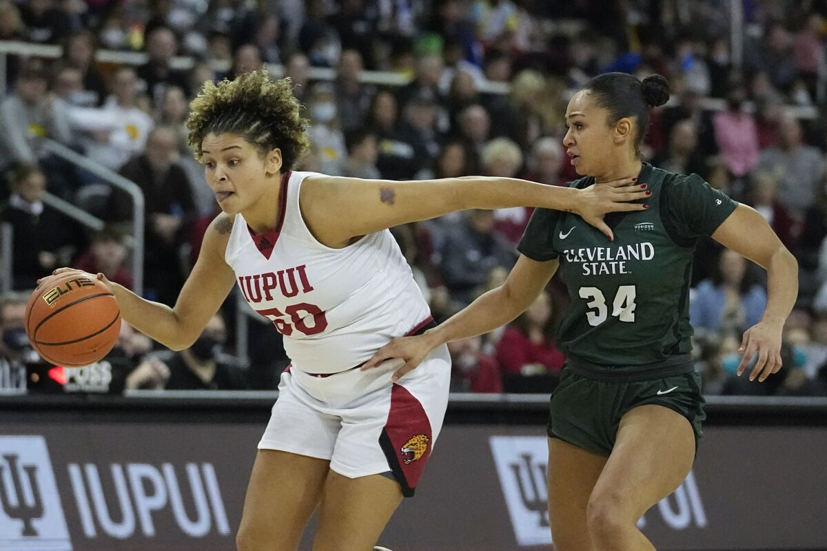 IUPUI's Macee Williams (50) goes to the basket against Cleveland State's Gabriella Smith (34) during the first half of an NCAA college basketball game in the Horizon League women's tournament championship, Tuesday, March 8, 2022, in Indianapolis. (AP Photo/Darron Cummings)