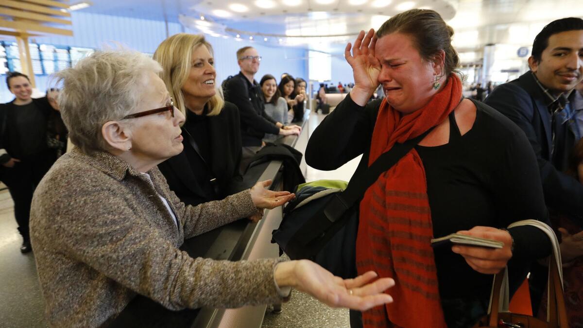 Nora Phillips, right, is in tears as she is greeted by fellow immigration attorney Helen Sklar, left, as Phillips arrived at Los Angeles International Airport. Phillips was sent home when her U.S. passport was flagged while she tried traveling to Mexico.