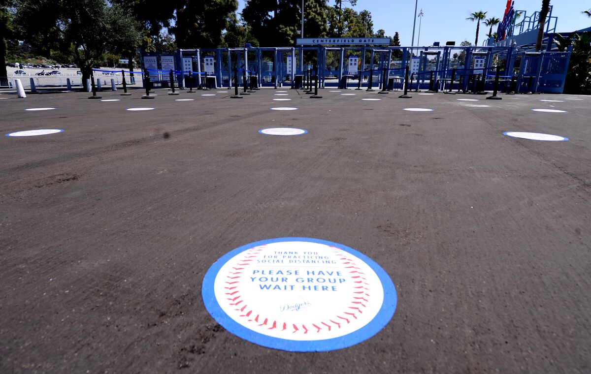 Markings for where fans should stand are placed on the ground outside the center field gate.