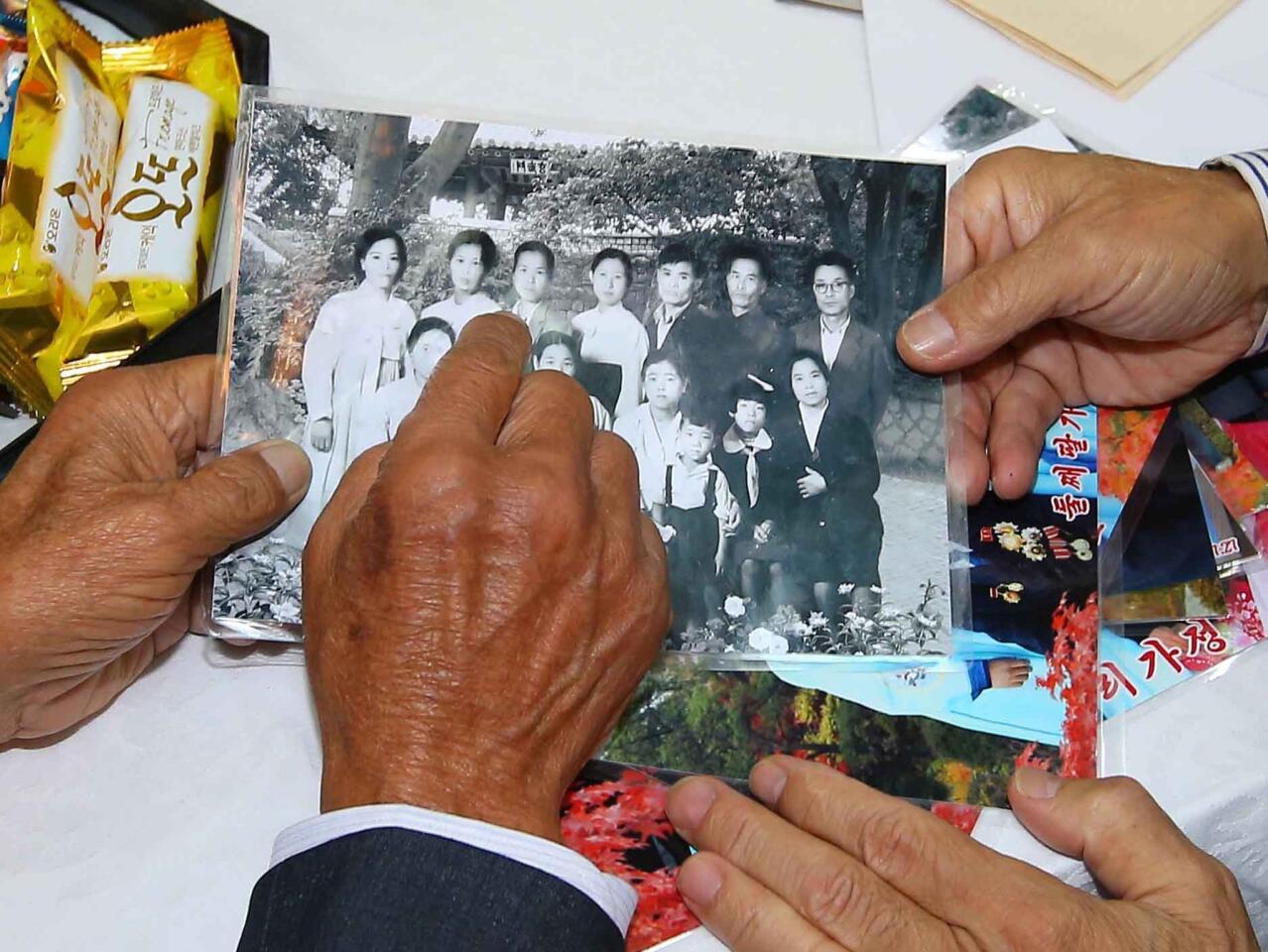 North Korean Sim Yeong-Sik, 85, points on his family picture to show his South Korean relatives during a family reunion on Oct. 20, 2015.