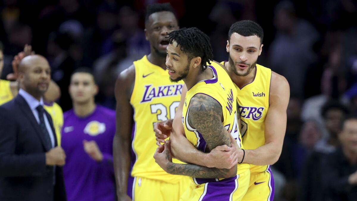 Brandon Ingram, front, celebrates with Larry Nance Jr., right, and Julius Randle after hitting a three-pointer to give the Lakers a 107-104 win over the Philadelphia 76ers on Dec. 7.