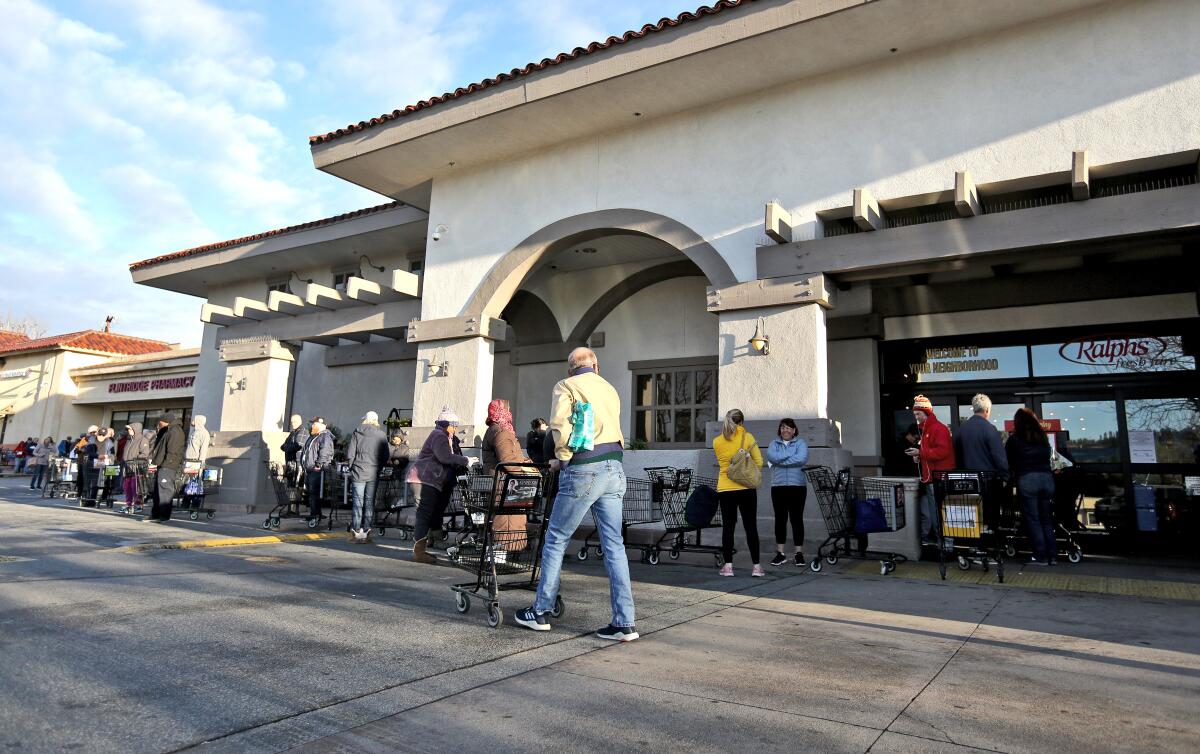 Dozens of shoppers lined up at the Ralphs supermarket before it opened in La Cañada Flintridge on Tuesday.