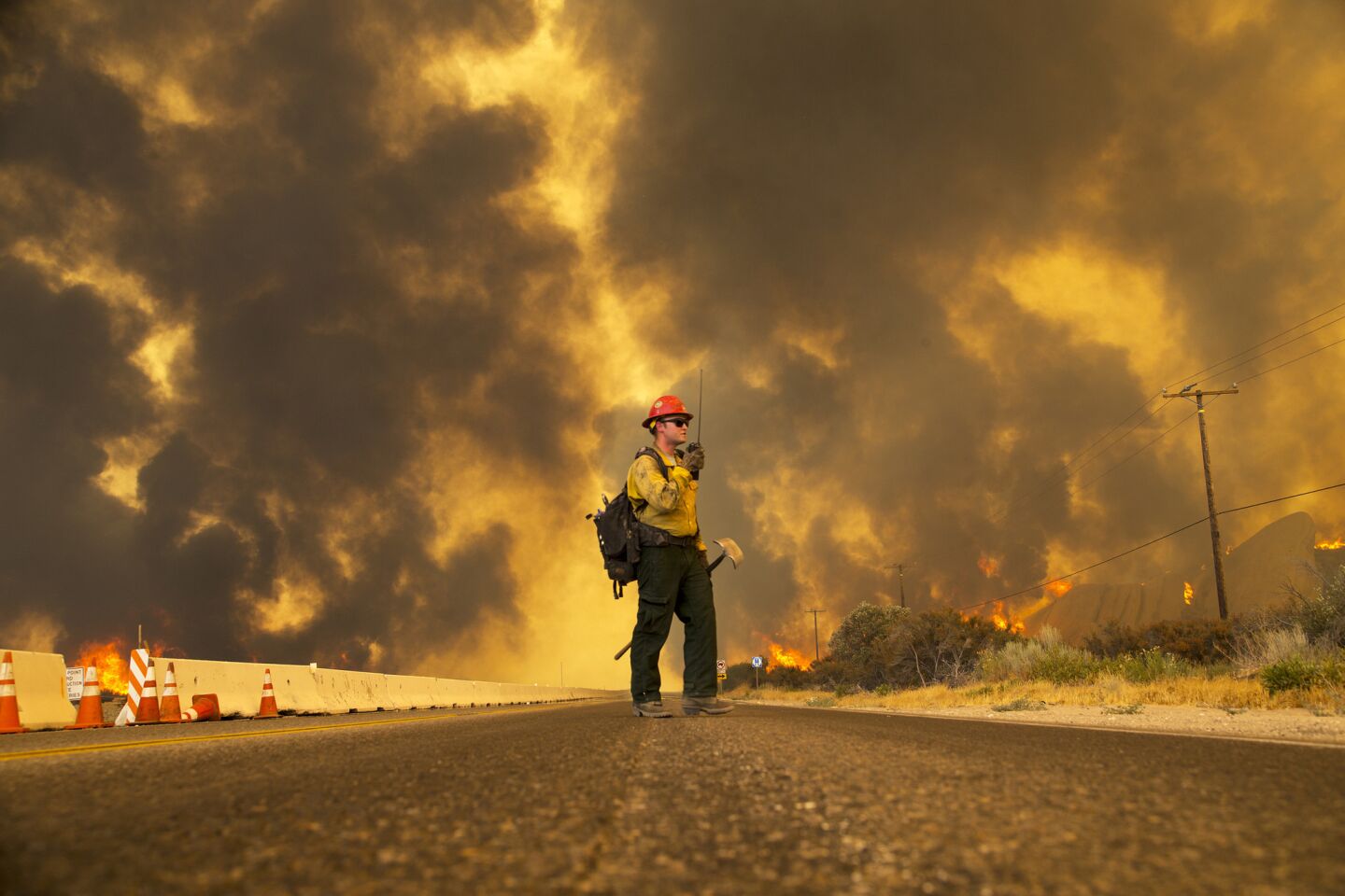A firefighter reports that the Blue Cut fire is burning on both sides of Highway 138 in Phelan, Calif.