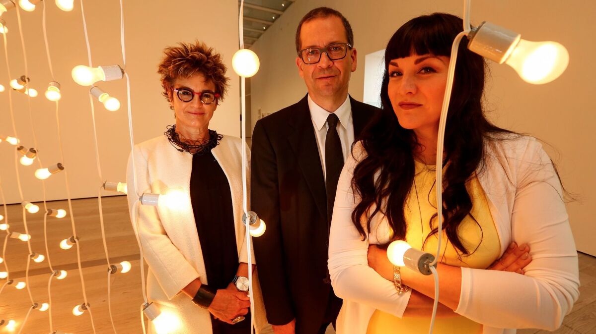 Curators Mari Carmen Ramirez, Chon A. Noriega and Pilar Tompkins Rivas stand next to a work by the late Felix Gonzalez-Torres at LACMA.