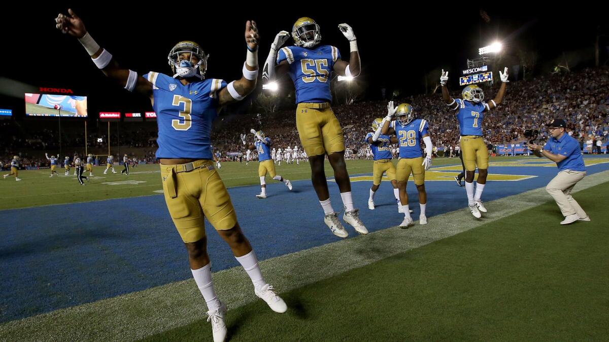 Members of the UCLA football team begin celebrating their 45-44 comeback victory over Texas A&M in the closing moments of the game on Sunday at the Rose Bowl.