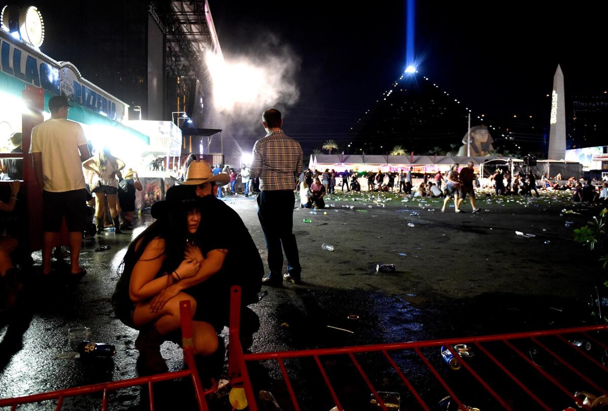 People take cover at the Route 91 Harvest country music festival in Las Vegas on Oct. 1 after gunfire was heard.
