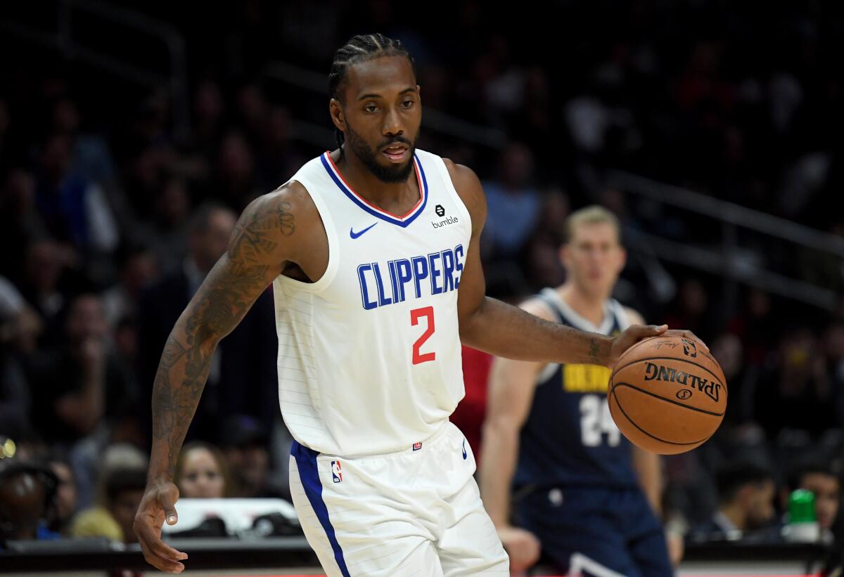 Clippers star Kawhi Leonard controls the ball against the Denver Nuggets.