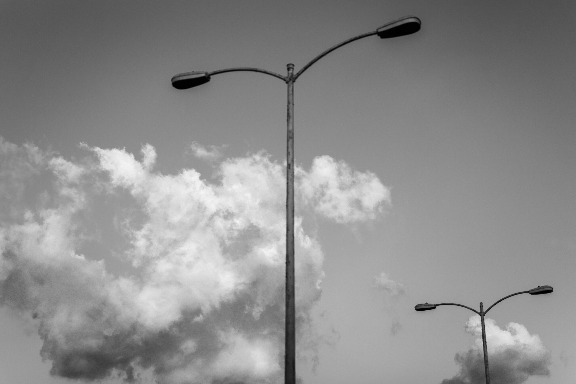 A tall streetlamp with a gray cloudy backdrop 