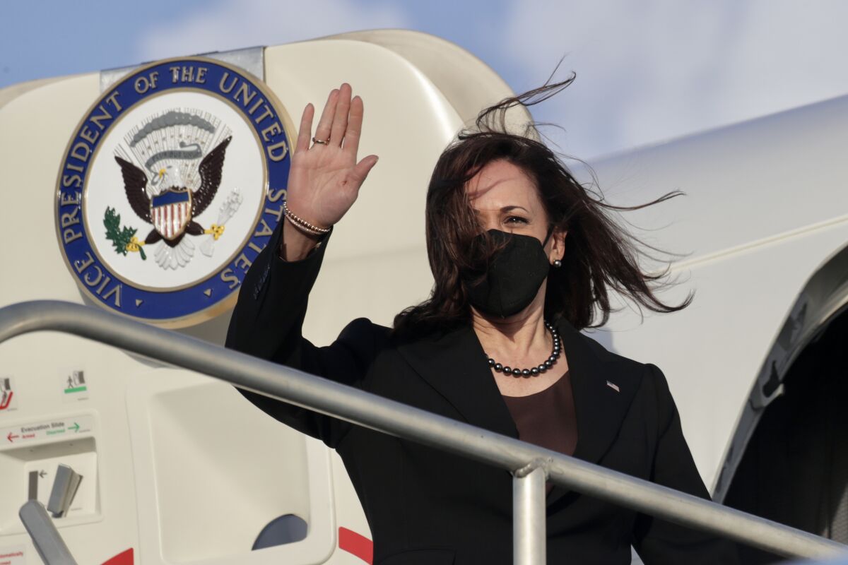 Vice President Kamala Harris waves as she boards Air Force Two.