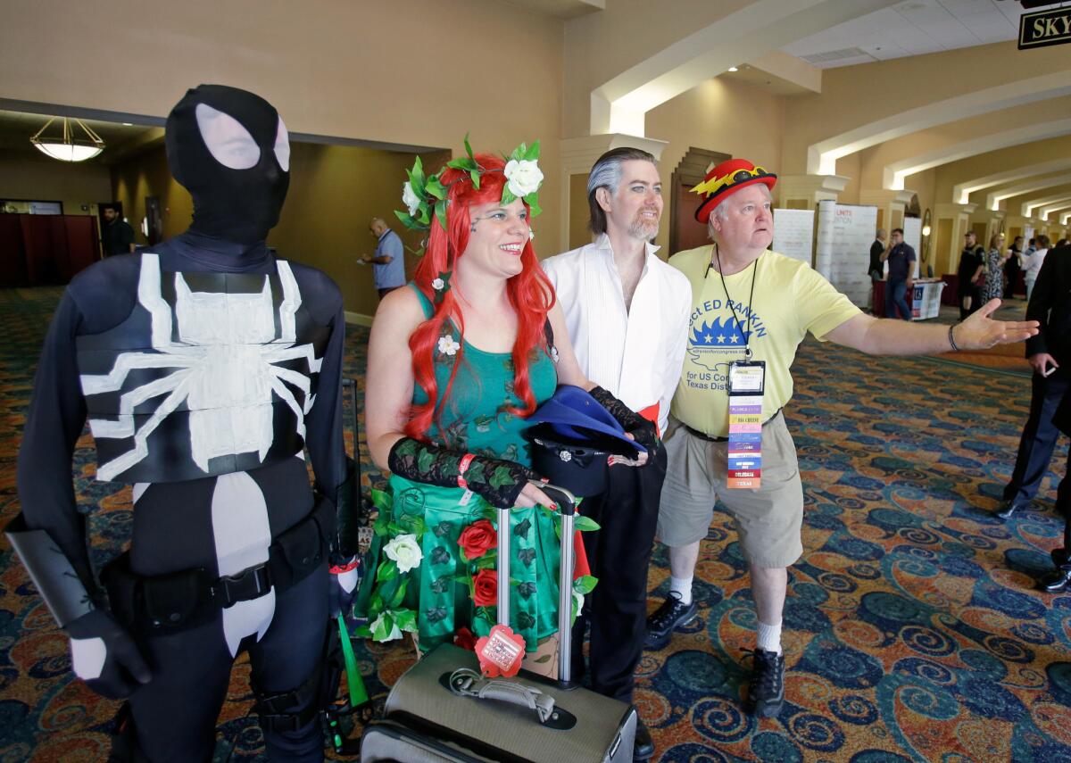 A Libertarian delegate, far right, poses with comic charters attending a convention next door to the National Libertarian Party Convention in Orlando on Friday.