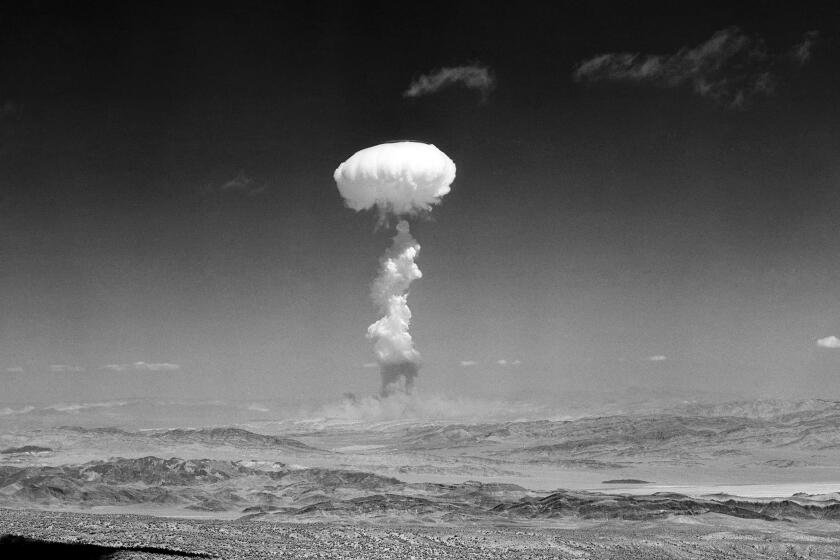 FILE - In this April 22, 1952 file photo a gigantic pillar of smoke with the familiar mushroom top climbs above Yucca Flat, Nev. during nuclear test detonation. A defense spending bill pending in Congress includes an apology to New Mexico, Nevada, Utah and other states affected by nuclear testing over the decades, but communities downwind from the first atomic test in 1945 are still holding out for compensation amid rumblings about the potential for the U.S. to resume nuclear testing. (AP Photo,File)