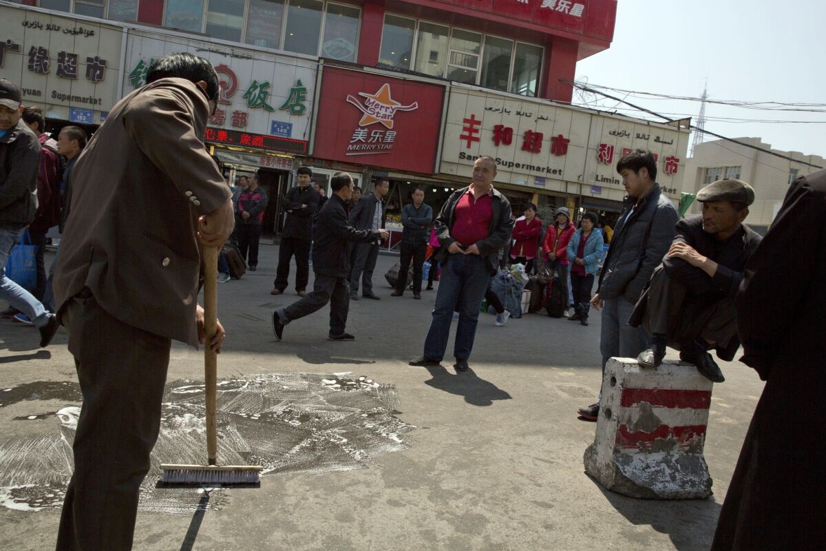 Men scrub the site of an explosion outside a railway station in Urumqi in northwest China's Xinjiang region.