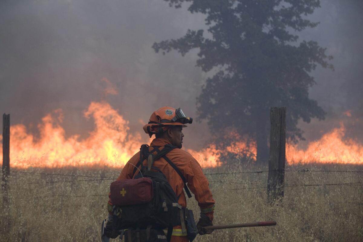 A member of an inmate firefighting crew works on the Bully fire on July 11.