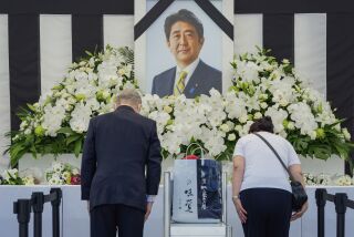 Personas dejan flores y presentan sus respeto al ex primer ministro de Japón Shinzo Abe a las afueras de Nippon Budokan, el martes 27 de septiembre de 2022, en Tokio. (Nicolas Datiche/Pool Photo via AP)
