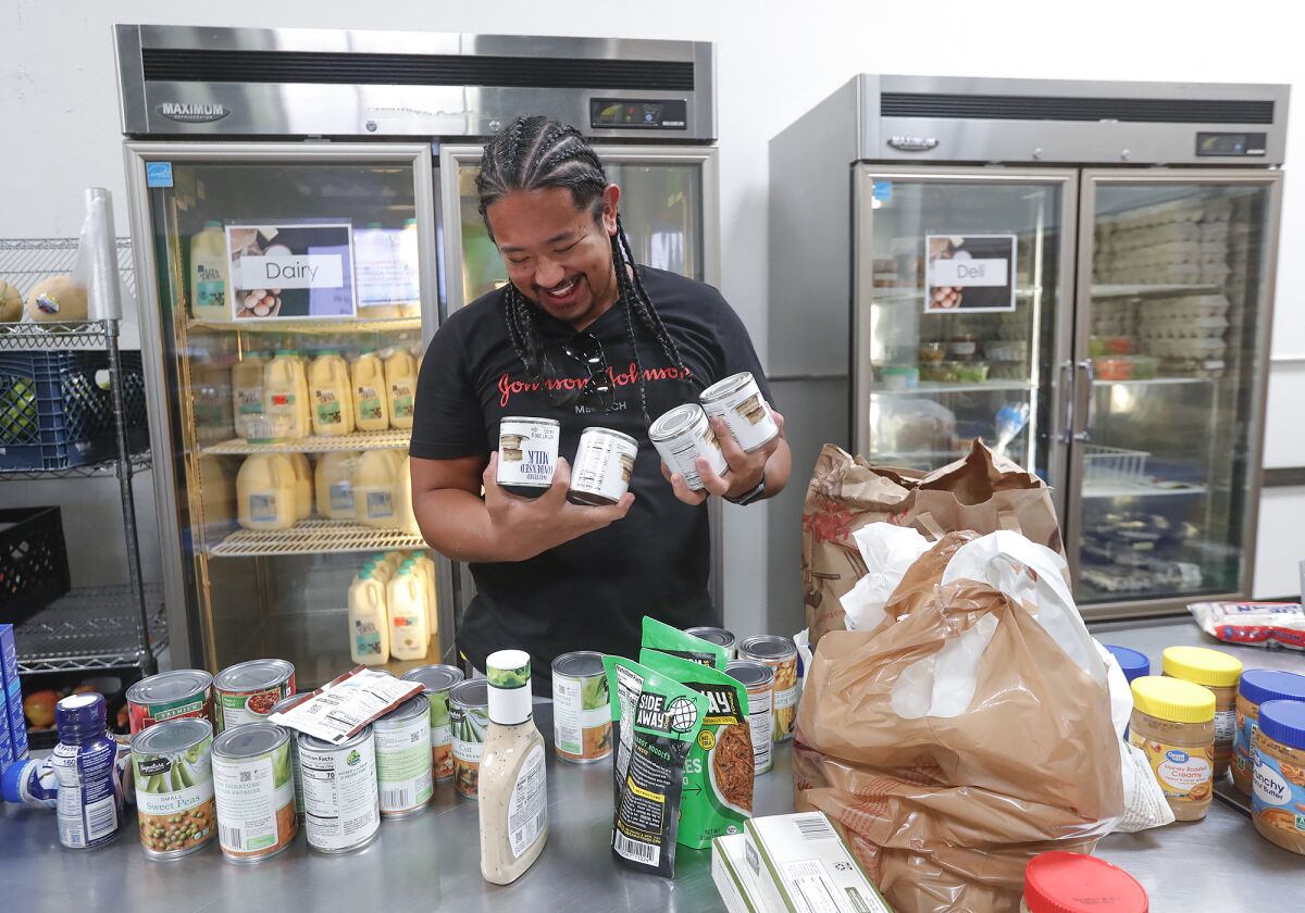 Volunteer Raimund Sevilla organizes food items at South County Outreach Food Pantry.