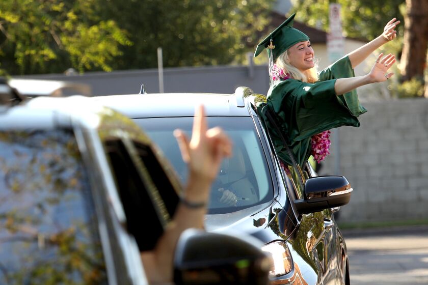 LOS ANGELES, CA - JUNE 10, 2020 - - Naomi Shacham waves to her teachers, off camera, during a drive-up graduation ceremony for the Class of 2020 at the New West Charter School in Los Angeles on June 10, 2020. Principal Dr. Sharon Weir and vice principal Mark Herrera handed each student, who remained in their cars, their diplomas. The graduation ceremony was suppose to take place at UCLA but due to the coronavirus pandemic had to revert to a drive-by graduation at the charter school. (Genaro Molina / Los Angeles Times)