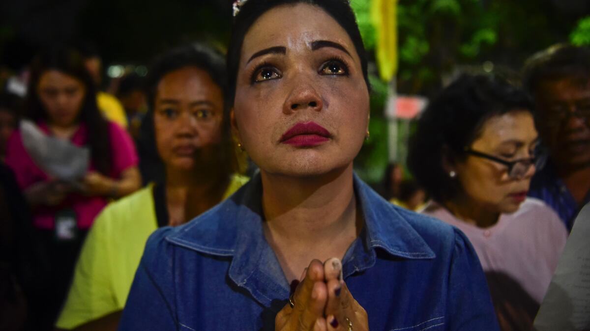 A Thai woman prays outside the hospital where King Bhumibol Adulyadej was being treated.