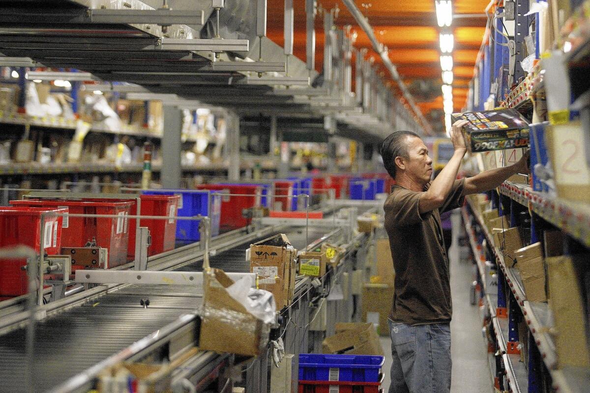 Nearly 100 workers staff Newegg's City of Industry fulfillment center six days a week. Above, Phuc Si handles an order.