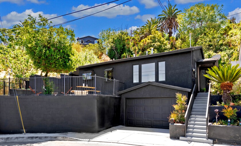 A black two story house with a staircase