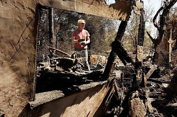 Roger Heath sifts through the remains of his burned home Tuesday in the Twin Lakes neighborhood of Chatsworth.