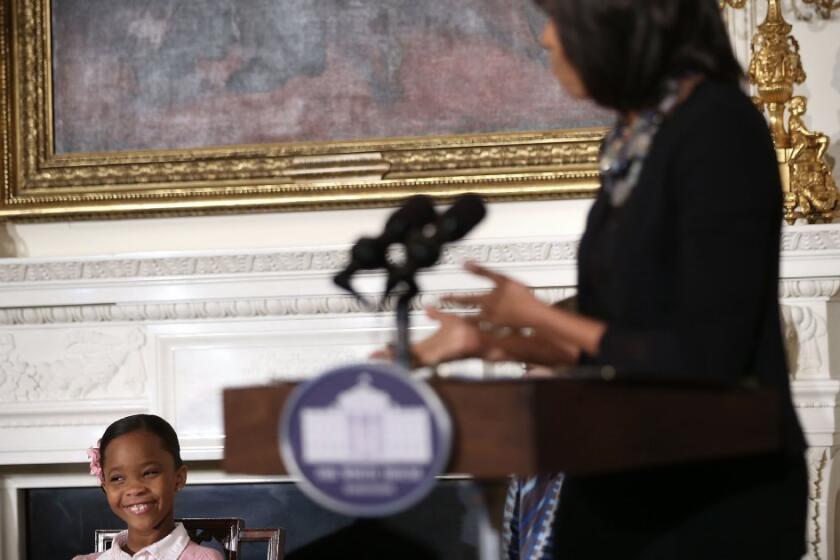 'Beasts of the Southern Wild' star Quvenzhane Wallis, left, listens as First Lady Michelle Obama speaks during an interactive student workshop at the State Dining Room of the White House in Washington, D.C.