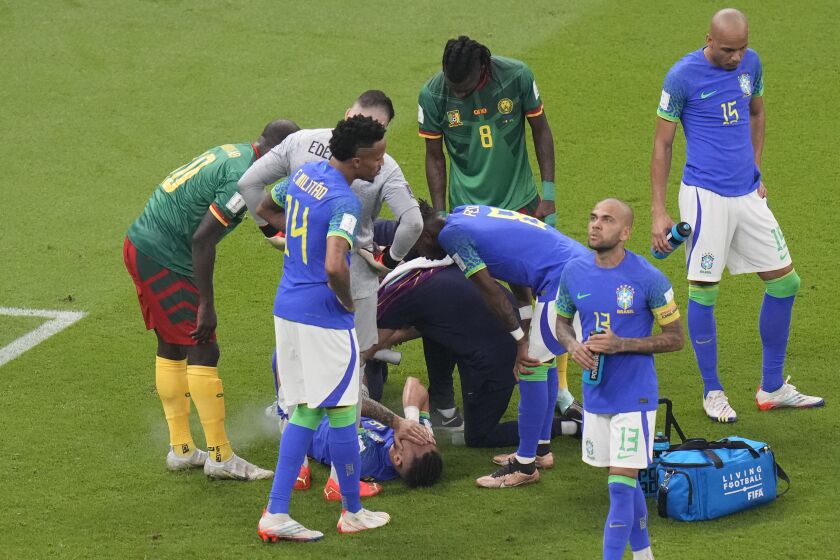 Brazil's Alex Telles is injured during the World Cup group G soccer match between Cameroon and Brazil, at the Lusail Stadium in Lusail, Qatar, Friday, Dec. 2, 2022. (AP Photo/Alessandra Tarantino)