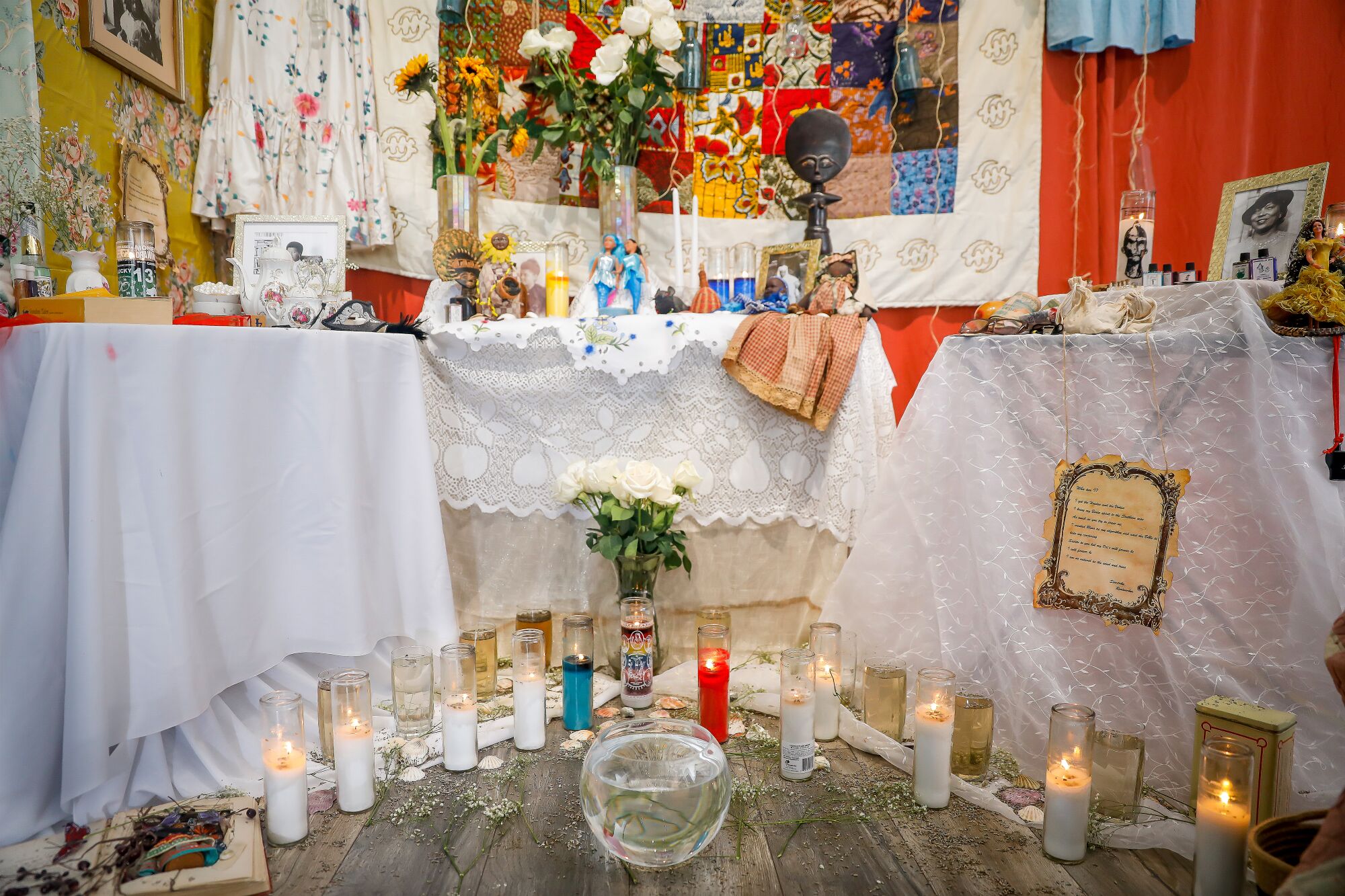 an altar on tables with white tablecloths and many candles 