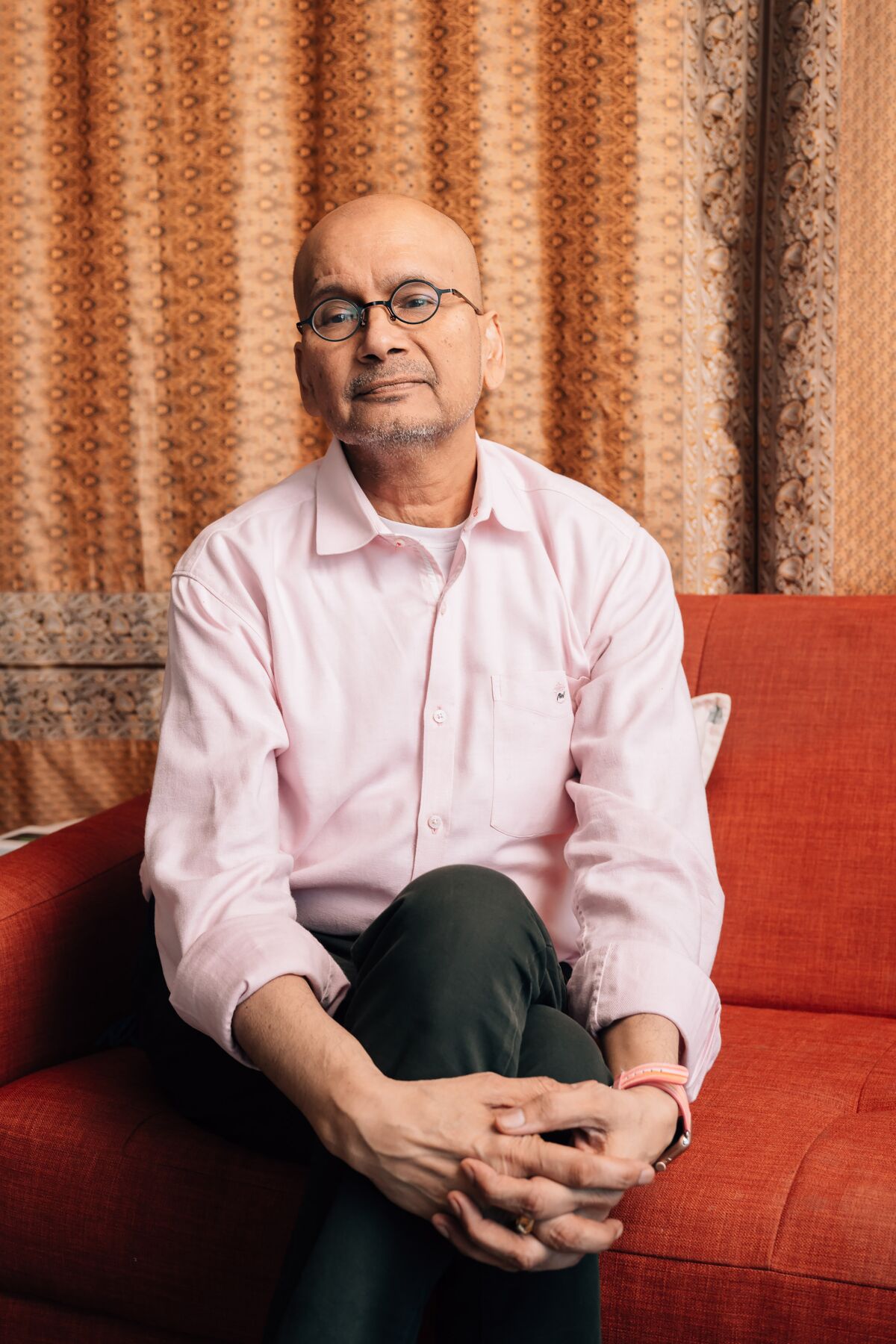 Cookbook author Raghavan Iyer sits on a couch.