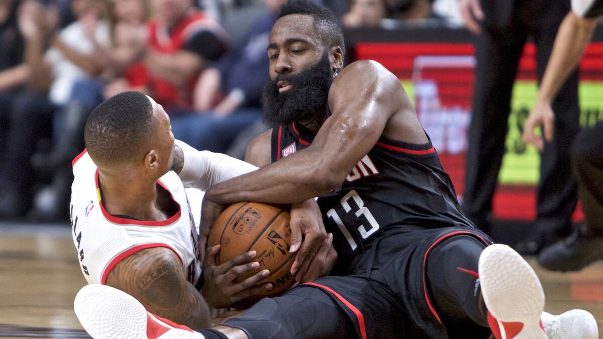 Rockets guard James Harden and Trail Blazers guard Damian Lillard scramble for the ball during the first half Sunday.