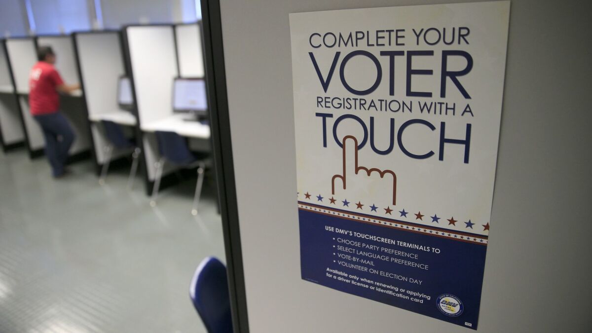 A sign advertises a touch-screen machine, a new process for voter registration at the Department of Motor Vehicles in Santa Ana.