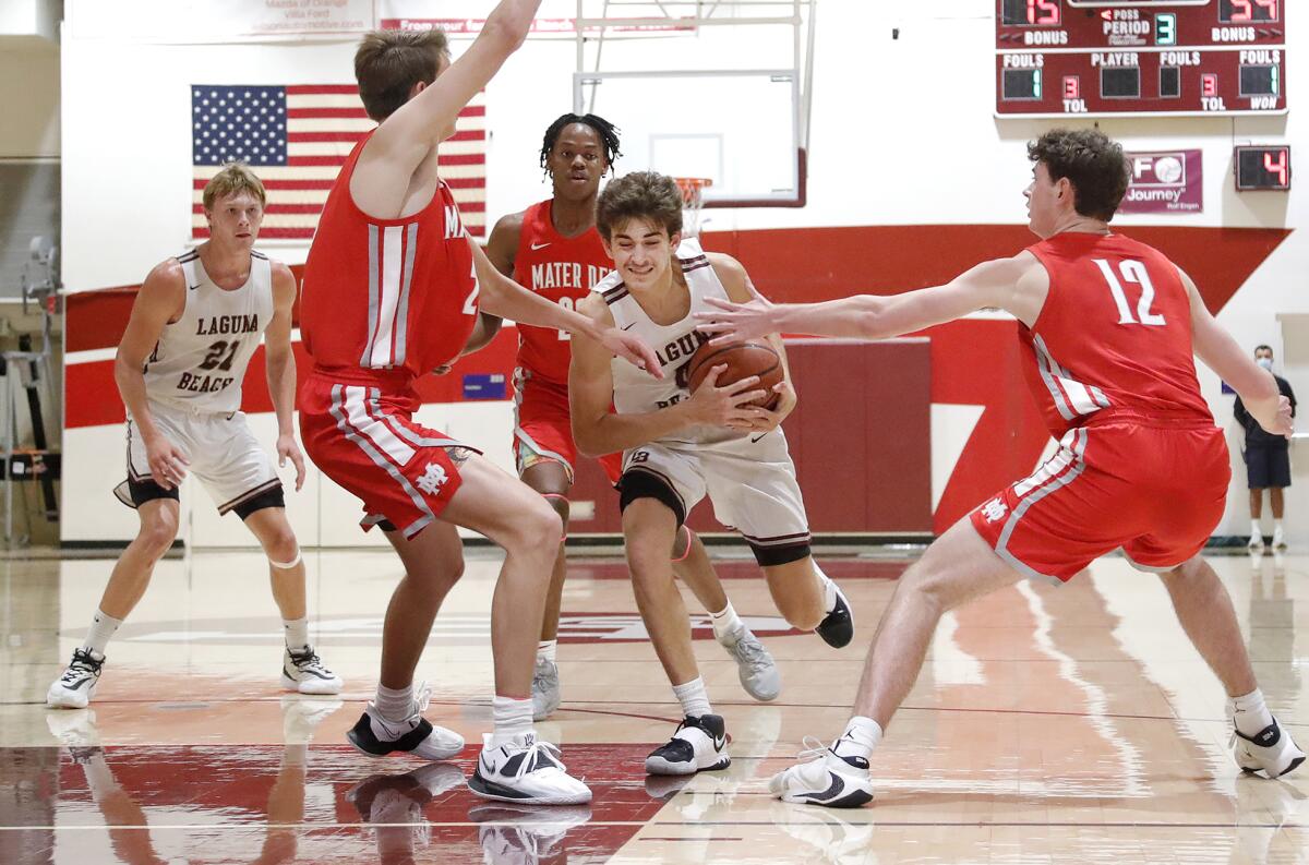 Laguna's Willie Rounaghi drives through the traffic of Mater Dei big men during Monday's nonleague basketball game.