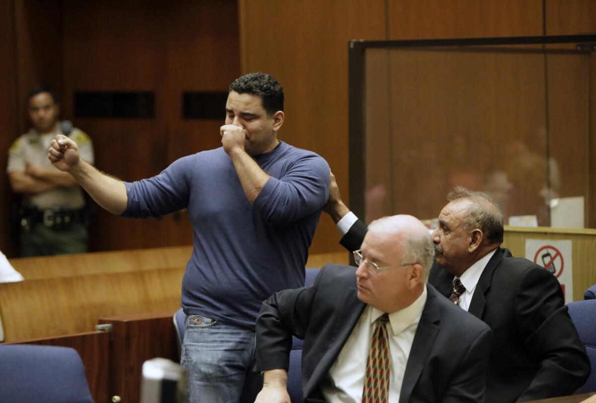 Former mayor of Bell Oscar Hernandez, right, reaches out to his his son, Agustin Hernandez, as he addresses the court before his father's sentencing Thursday.
