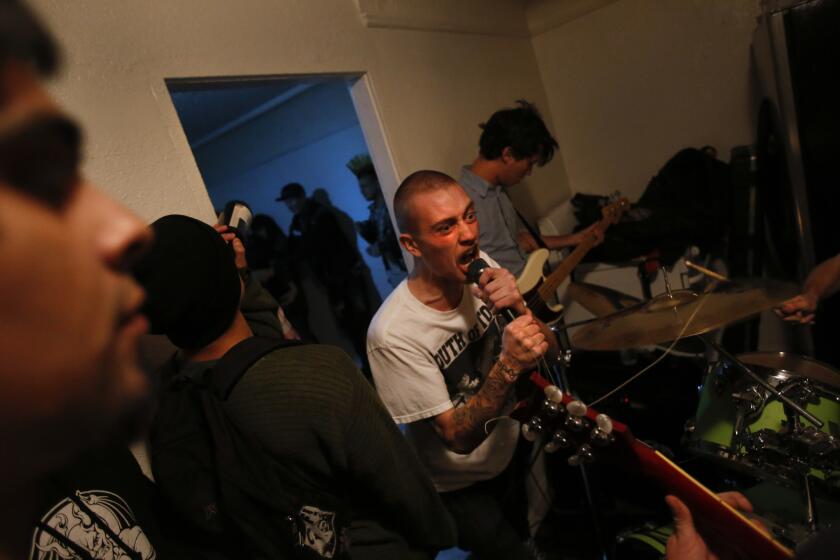 Chandler Herring, lead singer of The Testicle Difficulties, a punk band based in Orange County, sings in the cramped kitchen of a small home in the Florence district of South L.A.