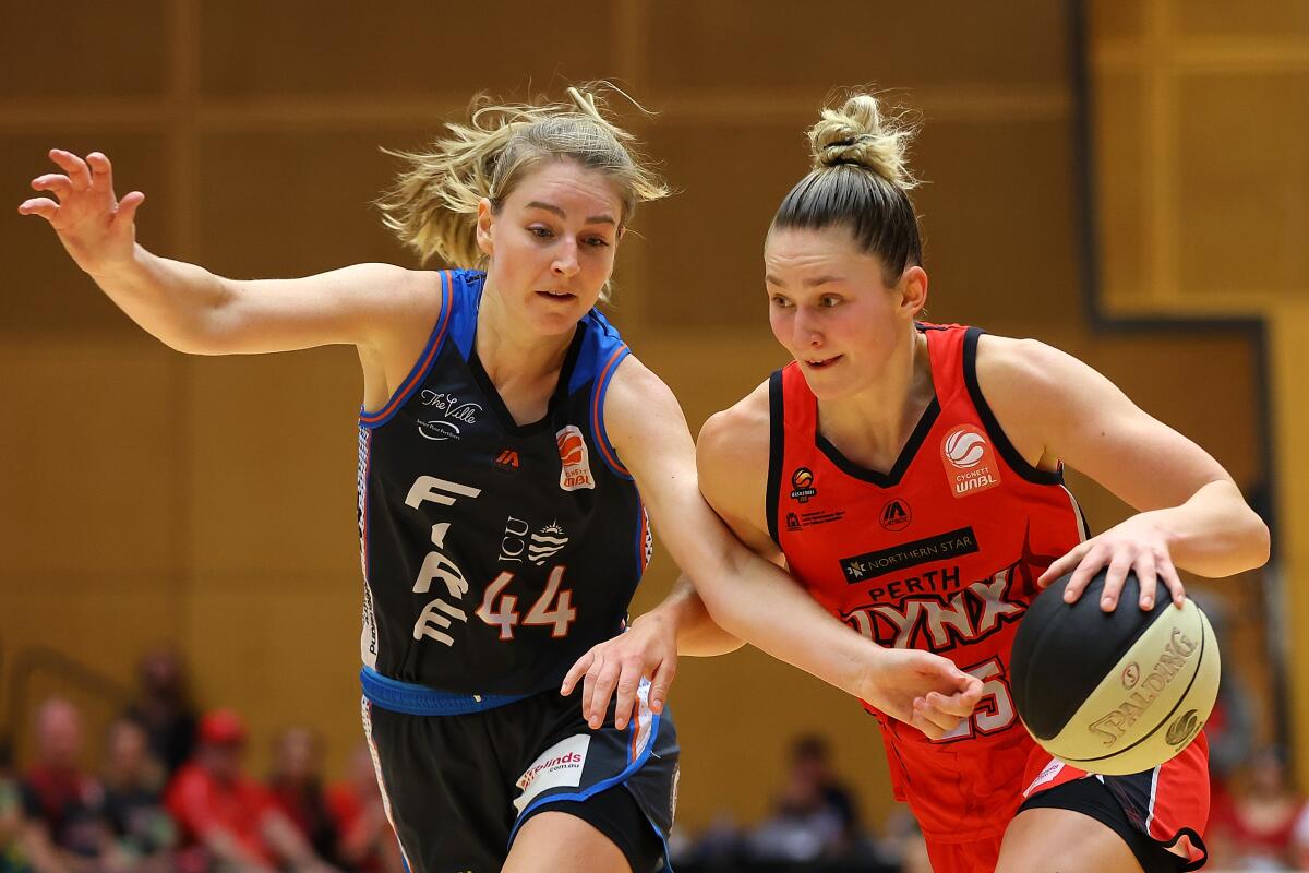 Amy Atwell of the Lynx controls the ball against Karlie Samuelson of the Fire during game two of the WNBL Semi Final series.