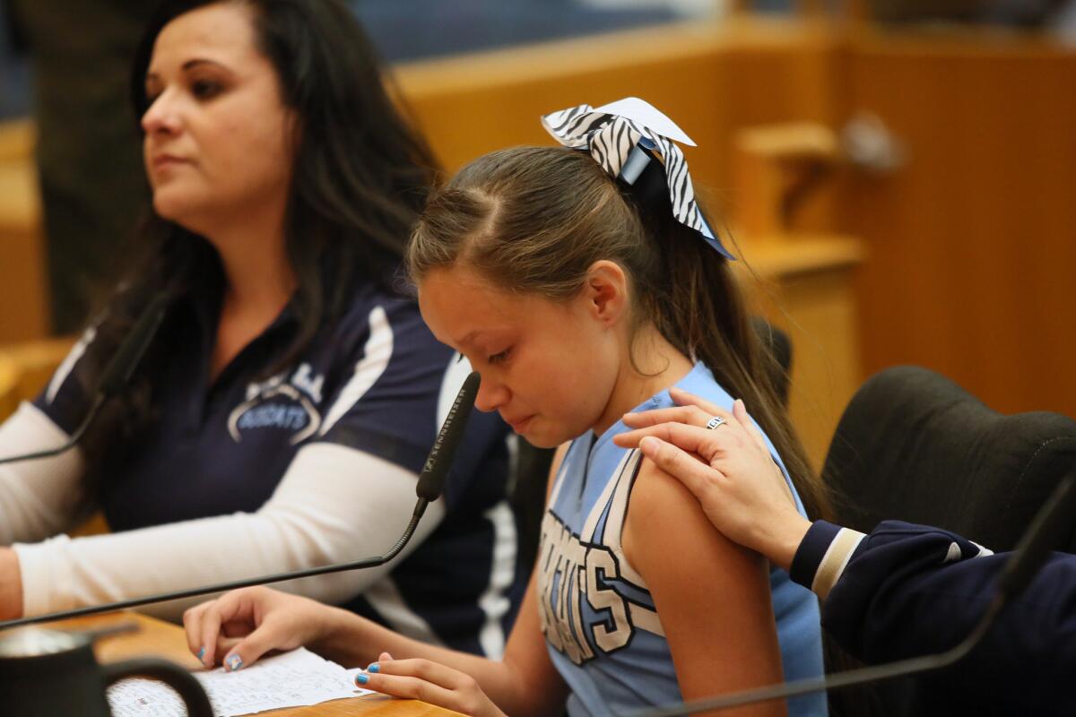 A parent reaches out to comfort 10-year-old Aaliya Mata who became emotional while pleading to Supervisor Gloria Molina and other members of the Board of Supervisors to lift the ban on her Bobcats team from playing in county parks.