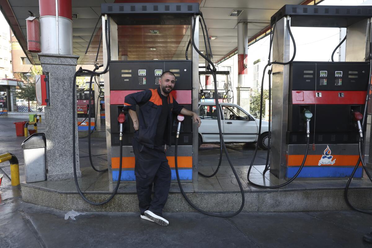 Gas station worker leaning on a gasoline pump