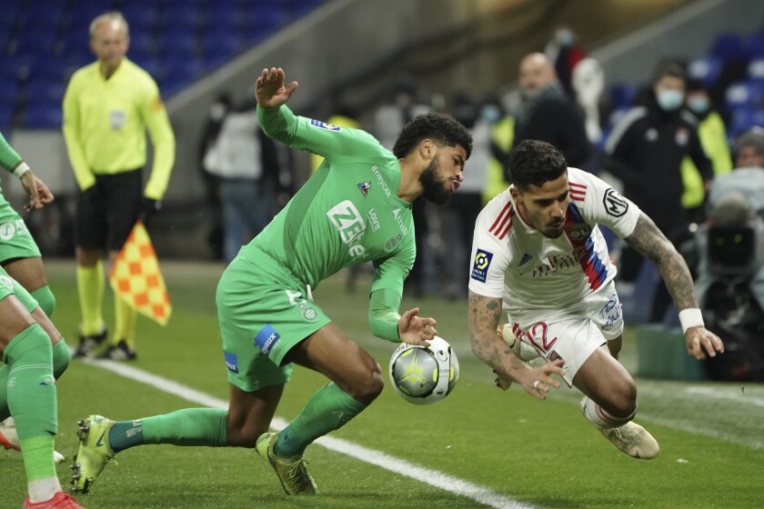 Lyon's Henrique, right, and Saint-Etienne's Mahdi Camara fight for the ball during the French League One soccer match between Lyon and Saint Etienne in Lyon, at the Groupama stadium in Lyon, France, Friday, Jan. 21, 2022. (AP Photo/Laurent Cipriani)