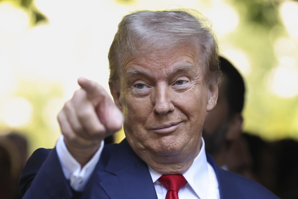 Donald Trump with a crooked smile and pointing 