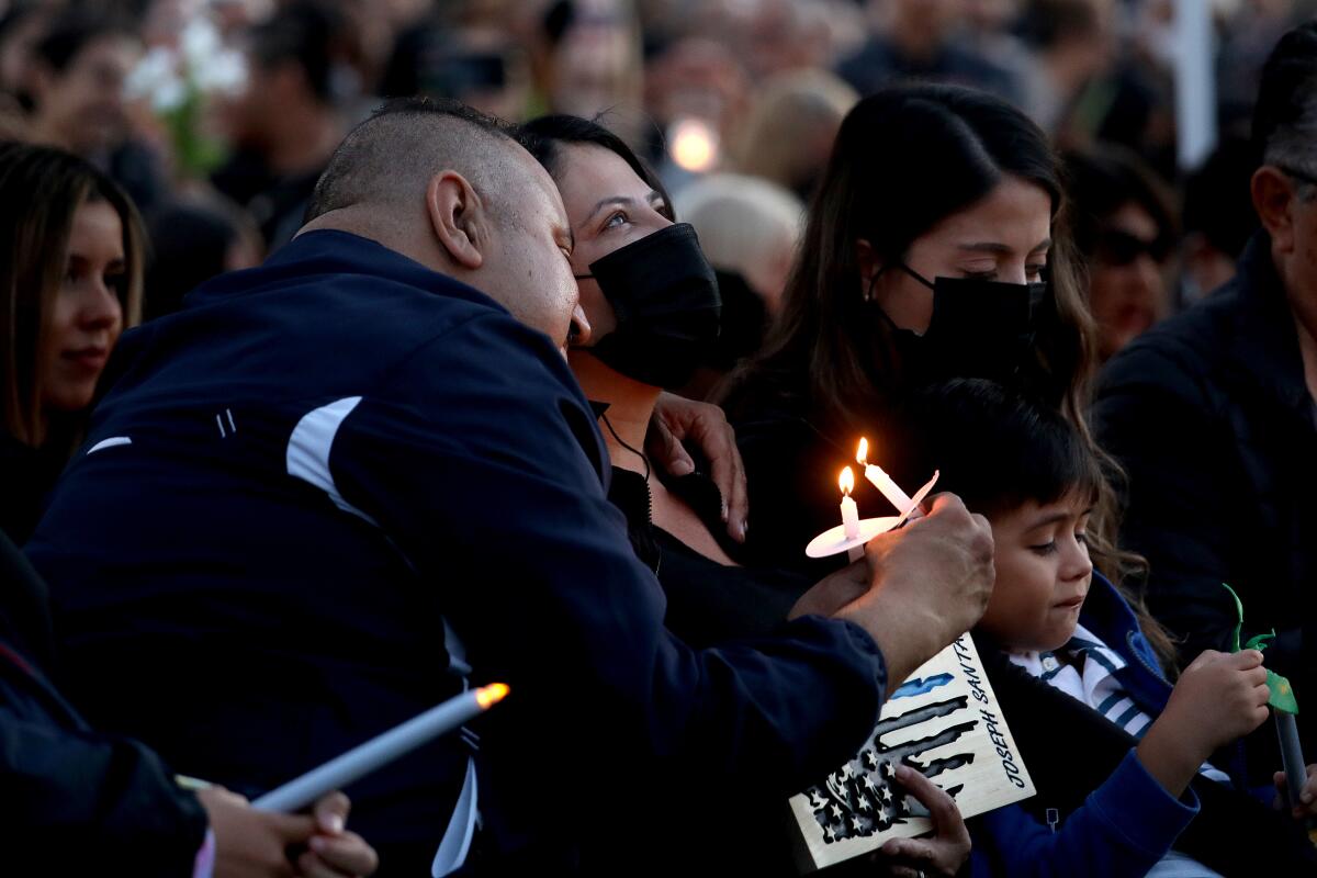 Olga Garcia, mother of fallen Officer Joseph Santana, looks to the sky at a candlelight vigil.