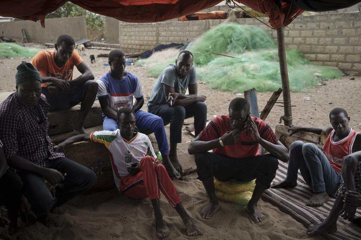 People sit under a tarp in Senegal.