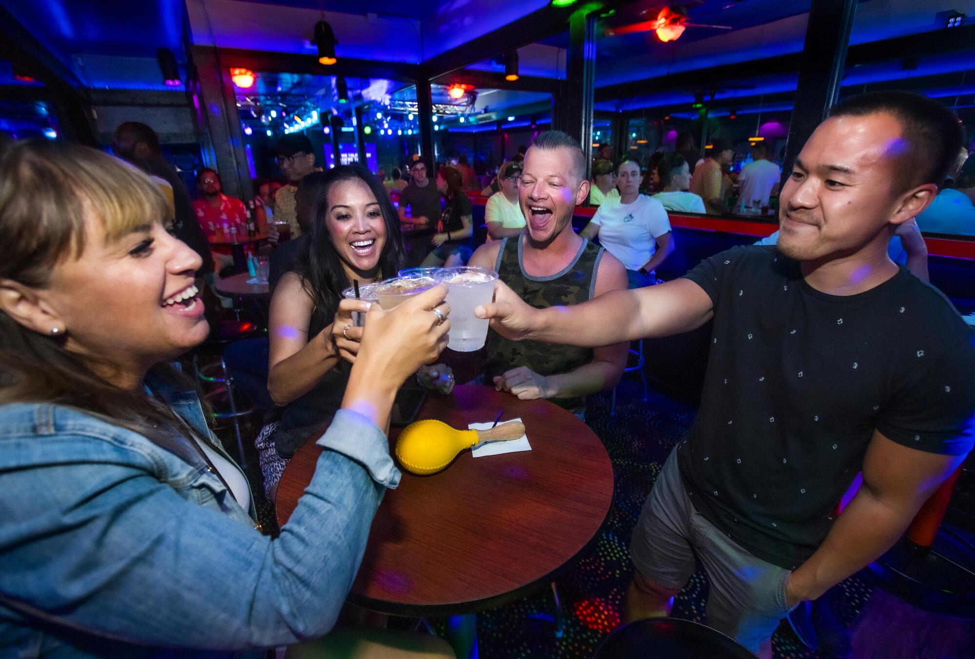 Four people clink glasses in a toast at the Boulevard.