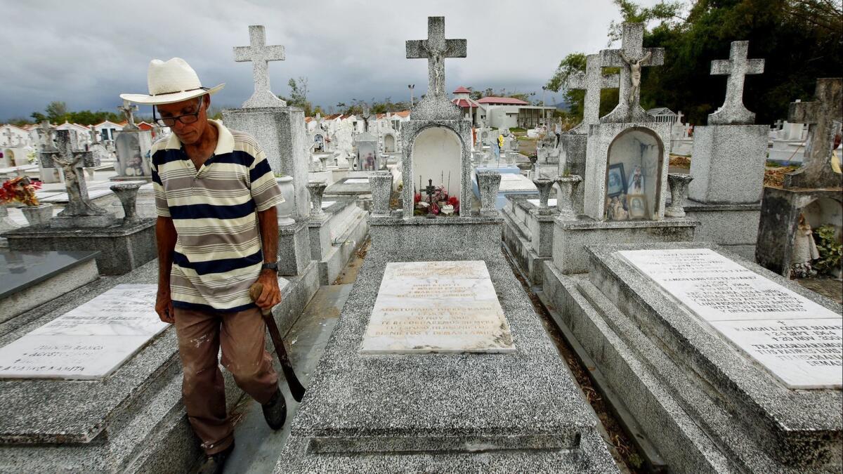 Heriberto Riveiro passes the grave of Leohermanijildo Cotte, whose death has been blamed on Hurricane Maria because it knocked out the power to his oxygen pump.