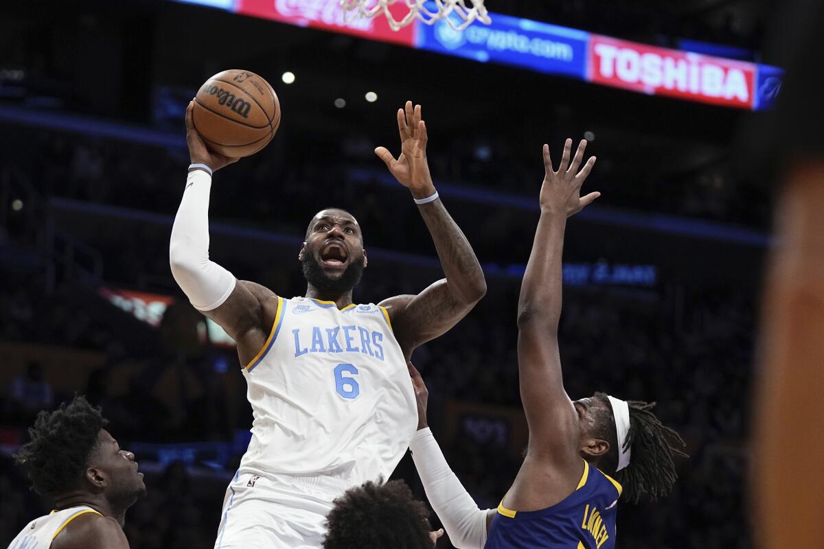Lakers forward LeBron James shoots as Golden State Warriors forward Kevon Looney defends.