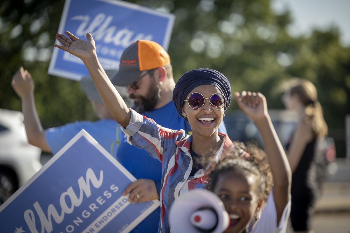 U.S. Rep. Ilhan Omar waves to passersby during a voter engagement event Tuesday in Minneapolis.