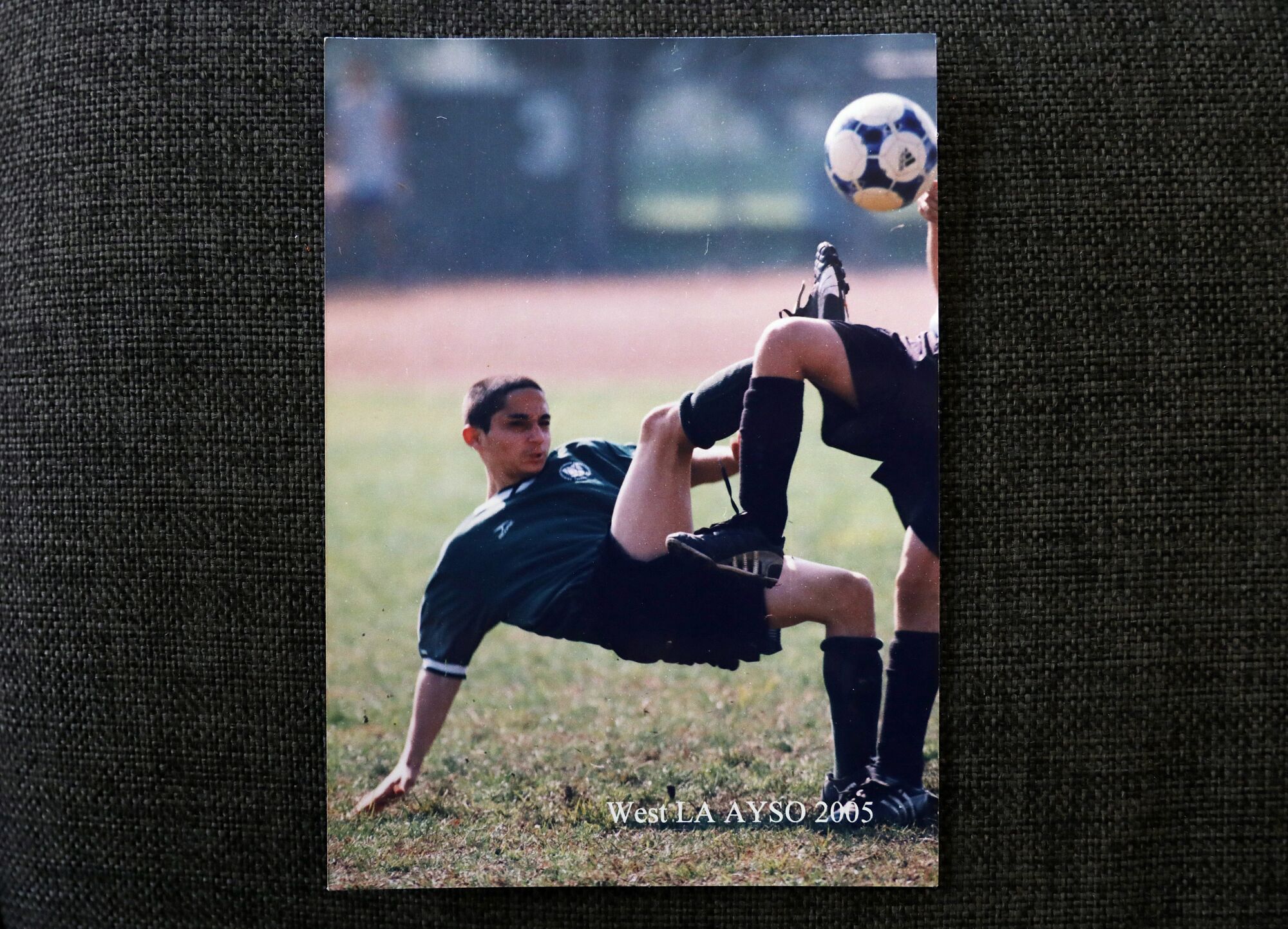 A boy kicks a soccer ball on a field
