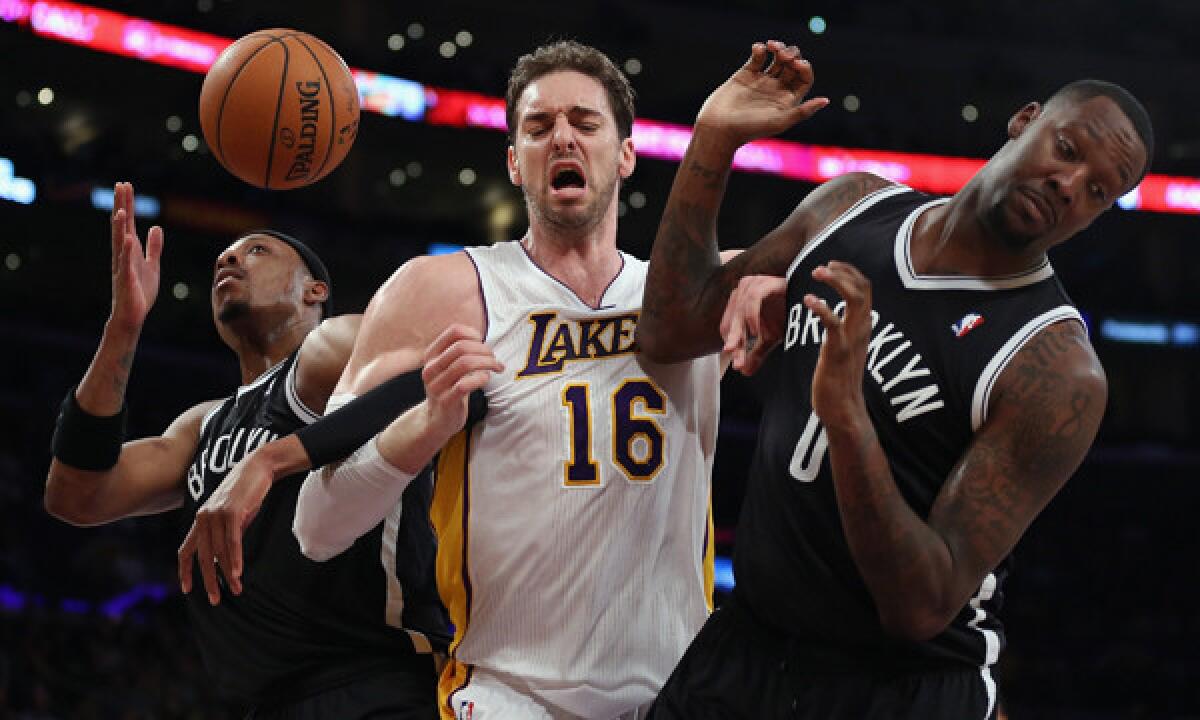 Lakers center Pau Gasol, center, battles the Brooklyn Nets' Paul Pierce, left, and Andray Blatche for a loose ball during the Lakers' loss Sunday.