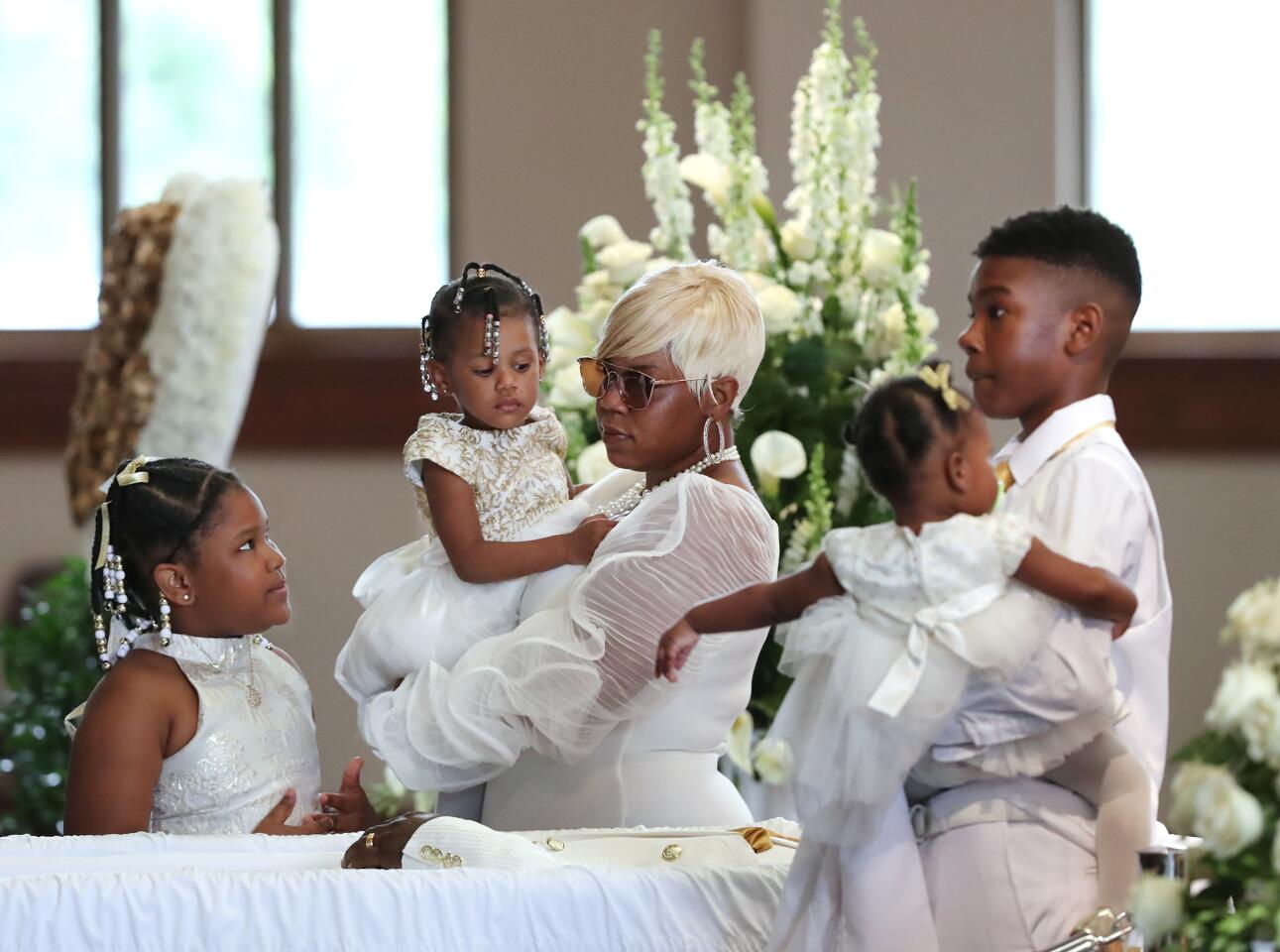 ATLANTA, GEORGIA - JUNE 23: Tomika Miller, wife of Rayshard Brooks, holds their 2-year-old daughter Memory while pausing with her children during the family processional at his funeral in in Ebenezer Baptist Church on June 23, 2020 in Atlanta. Brooks, 27, died June 12 after being shot by an officer in a Wendy's parking lot, sparking protests in Atlanta and around the country. The Rev. Raphael G. Warnock, senior pastor of Ebenezer, said "Rayshard Brooks wasn't just running from the police. He was running from a system that makes slaves out of people. A system that doesn't give ordinary people who've made mistakes a second chance, a real shot at redemption" (Photo by Curtis Compton-Pool/Getty Images)