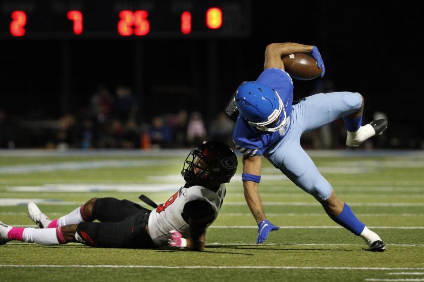 NORCO, CA - OCTOBER 15, 2021: Norco running back Jaydn Ott (8) tries to stay on his feet after being tackled by Corona Centennial defensive back Jaden Mickey (8) during the first half at Norco High School on October 15, 2021 in Norco, California.(Gina Ferazzi / Los Angeles Times)