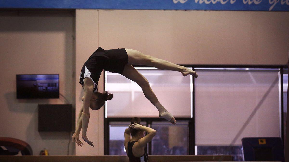 Madison Kocian practices on the balance beam at UCLA's Wooden Center.